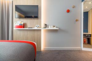 博德明Holiday Inn Express - Bodmin - Victoria Junction, an IHG Hotel的一间设有红色椅子和墙上电视的房间