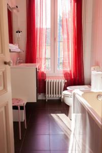 舒瓦西勒鲁瓦帕克酒店的浴室设有红色窗帘、卫生间和水槽。