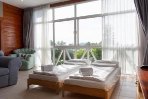 Ban Khanong Phra Klang (1)Golf View Suite Private Apartment Khao Yai的带大窗户的客房内的两张床