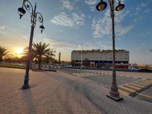 阿尔阿尔Qasr Alshamal Hotel的砖路上两盏路灯,有楼