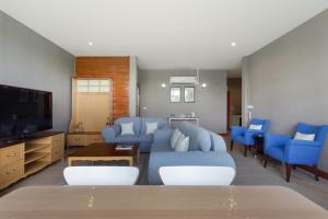 Ban Khanong Phra Klang (1)Golf View Suite Private Apartment Khao Yai的客厅配有蓝色的沙发和电视