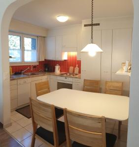 达沃斯Casa Berger的厨房配有白色的桌子和一些椅子