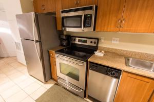默特尔比奇Deluxe Ocean front One Bedroom suite in Sandy Beach Resort的厨房配有不锈钢冰箱和微波炉。