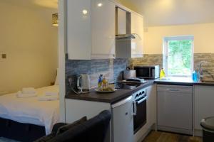 马特洛克Derwent View Holiday Apartments的一间带水槽和炉灶的厨房以及一张床