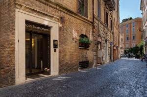 罗马Hotel Rinascimento - Gruppo Trevi Hotels的一条石铺街道,旁边是一座砖砌建筑