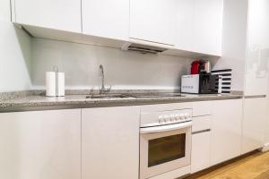 马德里Morar Apartments Malasaña的白色的厨房配有白色橱柜和水槽