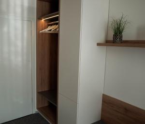 科切维Guest House Tri Zvezde的步入式衣柜,配有白色的墙壁和木制架子