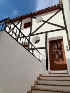 Perales de TajuñaCasa Castillo的白色的建筑,设有木门和楼梯