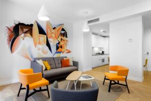 马德里Morar Apartments Malasaña的客厅配有沙发、椅子和绘画作品