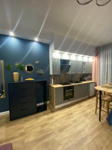克维曾Apartamenty Liwa的一间设有蓝色墙壁和桌子的大厨房