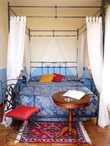 蒙特卡蒂尼泰尔梅小城堡酒店的一间卧室配有一张带木桌和桌子的床铺。