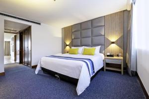 麦德林圣费尔南多广场酒店 的酒店客房配有一张带黄色枕头的大床