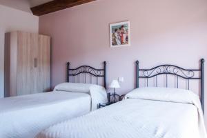 洛索亚河畔布伊特拉戈Apartamentos LA PARRA的配有粉红色墙壁的客房内的两张床