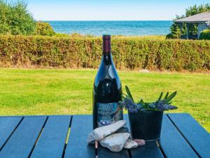 Nørager10 person holiday home in Alling bro的一瓶葡萄酒坐在野餐桌上,配上植物
