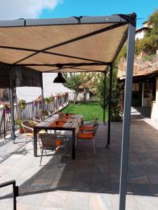 比略斯拉达德卡梅罗斯Casa rural La Media Legua的露台设有天篷下的桌椅