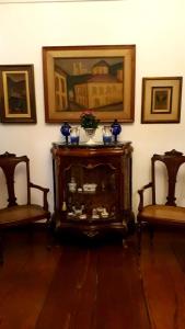 欧鲁普雷图Pousada Guignard的一间设有两把椅子和一张带镜子的桌子的房间