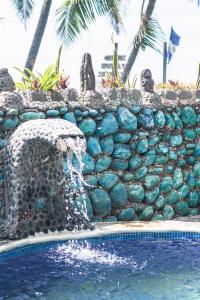 埃尔蒙特Olas Permanentes El Zonte的游泳池旁的岩石墙,带喷泉