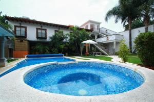 迪坡斯特兰Hotel Concierge Flor y Canto的一座大蓝色游泳池,位于房子前