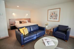 霍巴特萨拉曼卡公寓式酒店的一间卧室配有一张床、一张沙发和一张桌子
