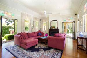 黑荒地赫斯蒙度假屋的客厅配有粉红色的沙发和两把椅子