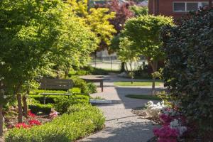 堪培拉福雷斯特公寓酒店的种有长凳、花草树木的公园