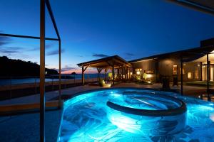 长崎艾兰长崎度假村的夜间在房子前面的游泳池