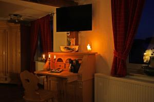 巴特拉斯费林登霍夫餐厅酒店的客厅配有电视和带壁炉的桌子。