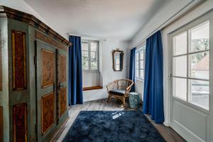 杜伦斯坦Smile Apartments zum Goldenen Strauß的一间设有蓝色窗帘、椅子和窗户的客房