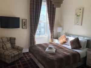 奥福德Haughton Arms Hotel的卧室配有床、椅子和窗户。