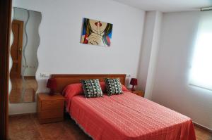 奥罗佩萨德尔马Galicia Vidaber Primera Línea的一间卧室配有一张红色棉被的床
