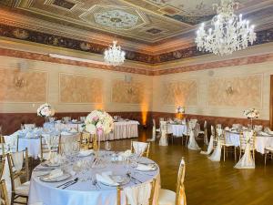 赫洛霍韦茨耶伦酒店的宴会厅配有白色的桌椅和吊灯