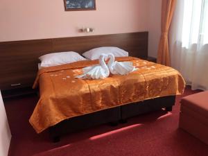 赫洛霍韦茨耶伦酒店的卧室里床边的两只天鹅
