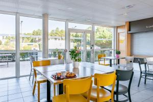 米奥B&B HOTEL Bordeaux Sud Mios 3 étoiles的用餐室设有桌椅和窗户。