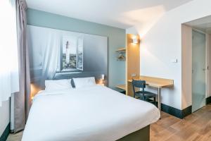 米奥B&B HOTEL Bordeaux Sud Mios 3 étoiles的配有一张床和一张书桌的酒店客房