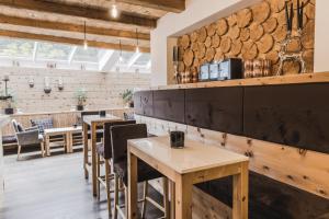 塞尔瓦迪加尔代纳山谷Hotel Chalet S - Dolomites Design - adults recommended的一间带木桌的餐厅和一间酒吧