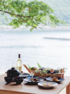 小滨市sea-auberge shitsumi 海のオーベルジュ志積的餐桌,带食物盘和一瓶葡萄酒