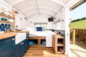 波尔佩罗Penlea Retreat Luxury Coastal Shepherds Hut 5 Minute Walk to Pubs and Village的一间小房子里的卧室,配有床