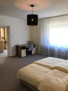 莱布尼茨Charmante Stadtwohnung im Zentrum von Leibnitz的一间卧室配有一张床、一张书桌和一个窗户。