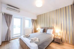 布加勒斯特New luxury flat at Unirii Square, Piata Unirii的一间卧室配有一张大床和两条毛巾