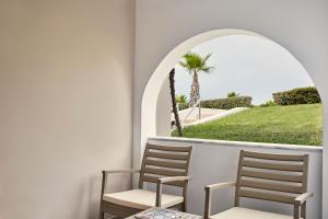 马斯蒂查里Atlantica Marmari Palace的两把椅子坐在棕榈树阳台