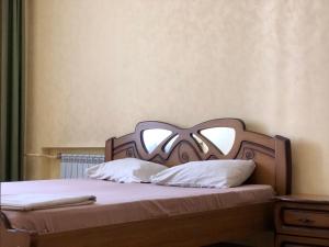 第聂伯罗Elit Aparts on Puskina WIFI的一张带木制床头板和白色枕头的床