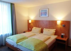 杜塞尔多夫明伽藤酒店的一间设有大床和窗户的酒店客房