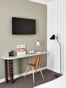 巴黎巴拉迪酒店的一张桌子、椅子和墙上的电视