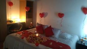 波哥大图卡萨酒店的墙上有红色心的床铺和气球