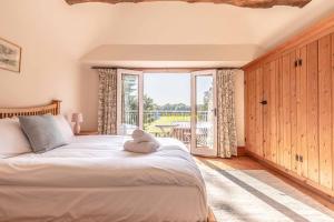 White WalthamChestnut Cottage - Stunning Countryside Views! PARKING, 4 BED, 3 BATHROOMS的一间卧室设有一张床和一个大窗户