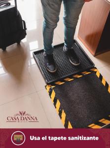 科利马Hotel Casa Danna的站在地板上欢迎垫上的人