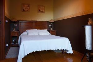 CamocaCasa Lolo de Villaviciosa的一间卧室配有一张带白色床罩的床