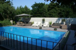 泰赫伦Villa Wambach的一个带桌椅和遮阳伞的游泳池