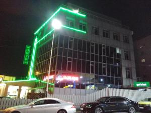 布加勒斯特Lion's Hotel的上面有绿灯的建筑