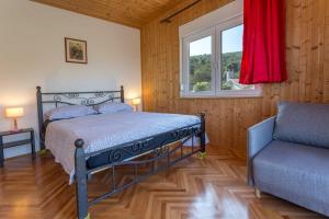 斯塔里格勒Holiday Home Antonija的一间卧室设有一张床、一个窗口和一把椅子